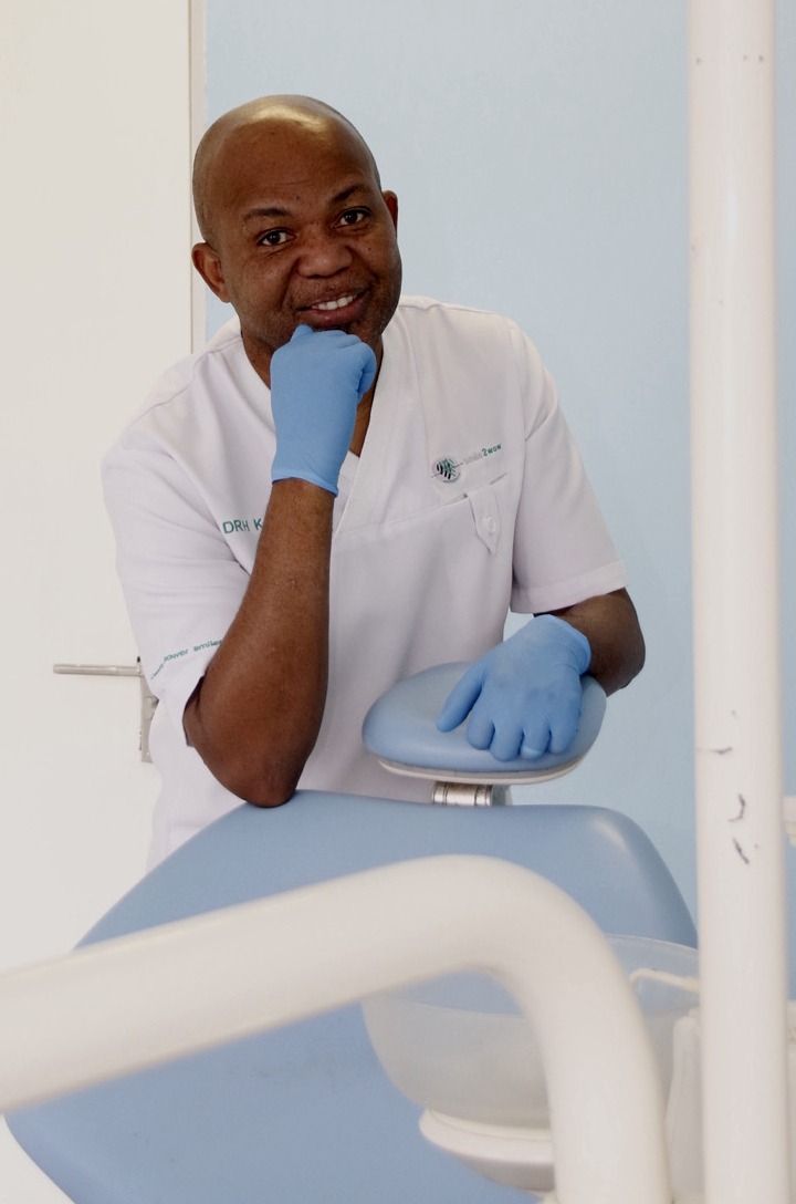 Dr. HN Kone, an experienced dentist with expertise in orthodontics, fast braces, and aligners, smiling confidently in a professional clinic setting.